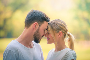 Portrait image of Young couple enjoying in the park at sunset. Concept romantic and love. Warm tone.