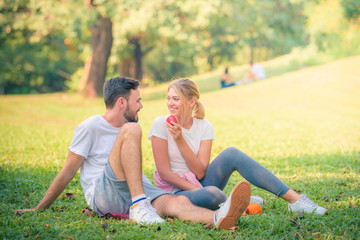 Fototapeta premium Portrait image of Young couple enjoying in the park at sunset. Concept romantic and love. Warm tone.