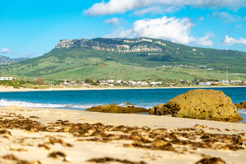 a beach scene with a mountain peak behind taken at bolonia beach in Andalucia, Spain 