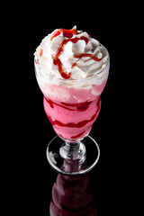 Milkshake. A cool drink of milk, ice cream, chocolate, vanilla, strawberries, on a black background with stones and ice. Cocktail card for a bar or restaurant iisolated on black 