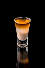 Alcoholic cocktails B-52 in shot glasses (shooters).  Cool drink from strong vodka, whiskey, coffee liqueur, baileys. Isolated on black background. Cocktail card for a bar or restaurant.