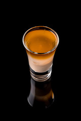 Alcoholic cocktails B-52 in shot glasses (shooters).  Cool drink from strong vodka, whiskey, coffee liqueur, baileys. Isolated on black background. Cocktail card for a bar or restaurant.