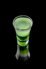 Green mexican. Alcoholic cocktails in shot glasses (shooters).  Cool drink from strong vodka, whiskey and sweet liqueurs isolated on black background. Cocktail card for a bar or restaurant.