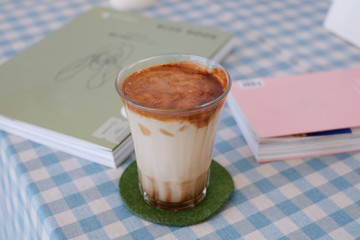  A cup of hot coffee latte, milk and coffee shot with caramel syrup on top , coffee shop background  