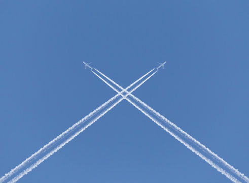 Crossing Of Two Aircraft Traces In A Blue Sky