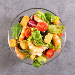 bowl of shrimp salad with tomato, olive and crouton