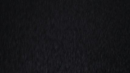 Fototapeta premium 4k Heavy angled rain falling in front of the camera against black screen. Raindrops splashing. Rain closeup vfx insert. Practical seamlessly loopable footage. Heavy rainstorm hitting black surface.
