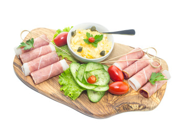 Pieces of Italian prosciutto on a wooden cutting board