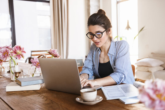 Image of lovely pretty woman typing on laptop while working or studying at home