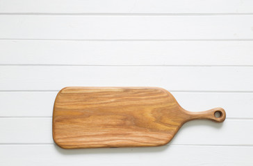 Empty kitchen cutting wooden  board on a green background. Top view. Copy space. 