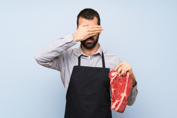 Chef holding a raw meat covering eyes by hands. Do not want to see something