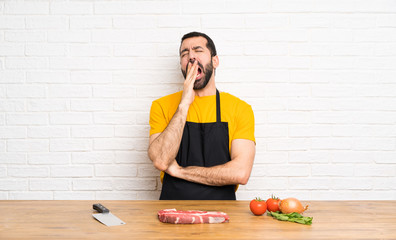 Chef holding in a cuisine yawning and covering wide open mouth with hand