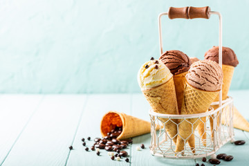 Waffle cones with homemade coffee, vanilla and chocolate ice cream on turquoise background. Healthy...