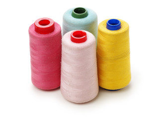 spools of thread for the textile industry on white background