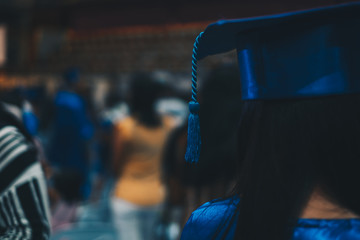 Headshot and rear view of a female graduate in blue academic attire. Selected focus. Copy space. - Powered by Adobe