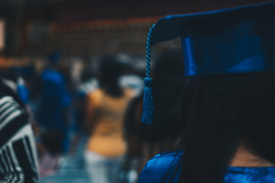 Headshot and rear view of a female graduate in blue academic attire. Selected focus. Copy space.