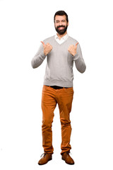 Handsome man with thumbs up gesture and smiling over isolated white background