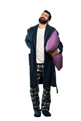 Fototapeta premium Man with beard in pajamas suffering from backache for having made an effort over isolated white background