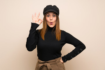 Fashion woman with hat surprised and showing ok sign