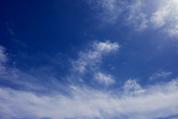 A deep blue sky with light white clouds background