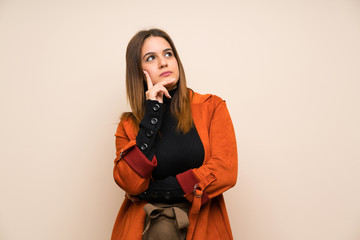 Young woman with coat thinking an idea