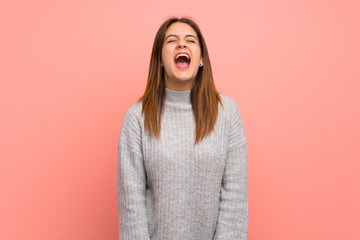 Young woman over pink wall shouting to the front with mouth wide open