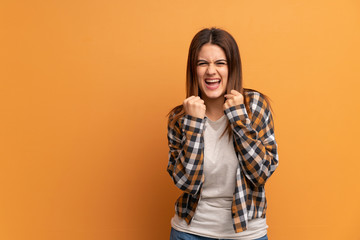 Young woman over brown wall frustrated by a bad situation