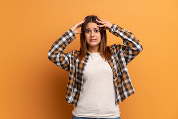 Young woman over brown wall with surprise expression