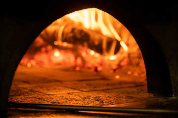 Image of a brick pizza oven with fire