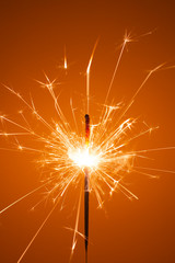 Party sparkler little fireworks on orange background.