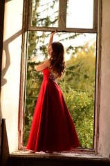 Beautiful modern girl in rad dress near the brickwall. Youth style. Fashion shot.