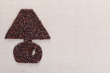 Lamp from coffee beans on linen texture aligned left.