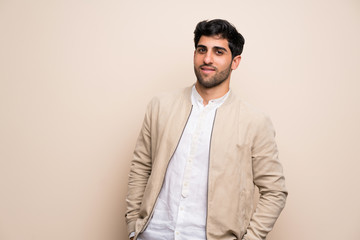 Young man over isolated wall laughing