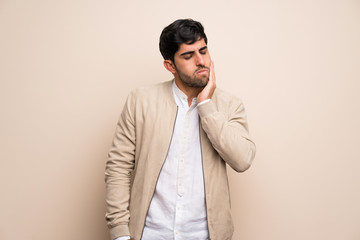 Young man over isolated wall with toothache
