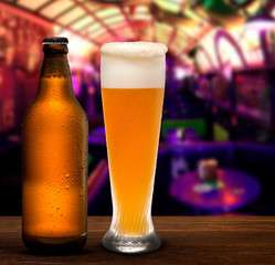 Branding and marketing concept for beer with a line of unopened unlabelled full blank brown bottles and beer cup on a pub background conceptual of Oktoberfest or nightlife.