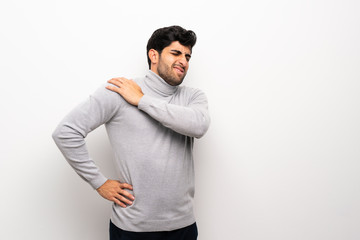 Young man over isolated white wall suffering from pain in shoulder for having made an effort