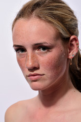 portrait of a young beautiful girl with blue eyes and freckles on a white background