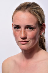 Obraz premium portrait of a young beautiful girl with blue eyes and freckles on a white background