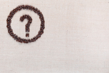 Question symbol in circle from coffee beans on linen texture, aligned top left.