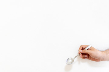 金属スプーンを持った男の手