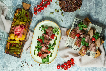 Cold meat snacks with pickled vegetables. Beautiful serving of dishes. Light gray background. Restaurant menu