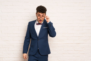 Man in suit and bow tie with glasses and surprised