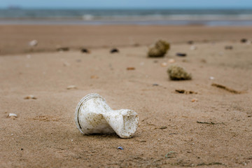 verre en plastique trainant sur le sable © Image'in