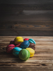 macaroons on wood table with cup and flowers