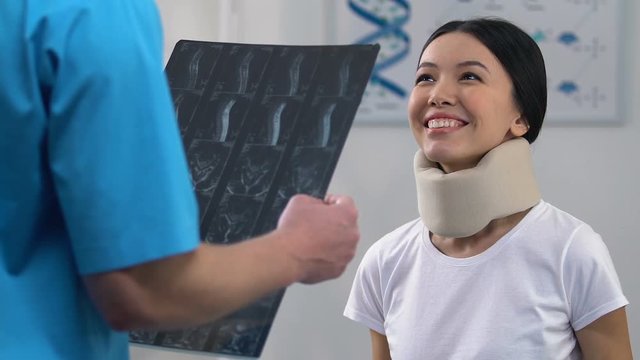 Smiling woman in cervical collar at doctors appointment, positive x-ray result