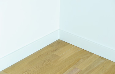 Parquet floor with a white wall, the corner of the room