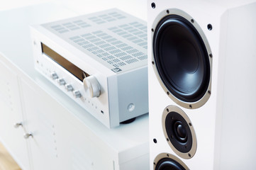 Modern audio stereo system with white speakers on bureau in modern interior - obrazy, fototapety, plakaty