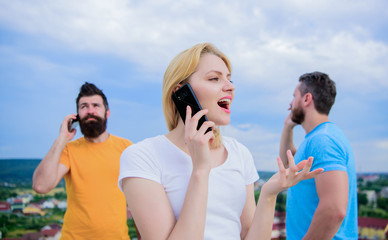Staying connected with one another. Modern people with smartphones outdoor. Mobile phone users....