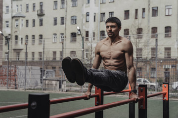 Athlete practicing calisthenics with smartwatch on his wrist.