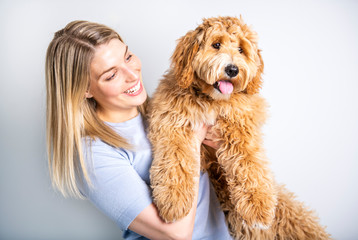 woman with his Golden Labradoodle dog isolated on white background